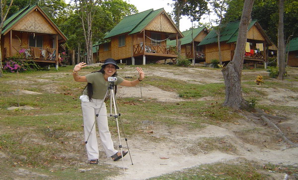 Ann lining up a picture, bungalows in background